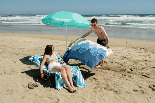Pareja disfrutando picnic en la playa para celebrar San Valentín al aire libre